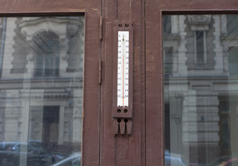 Fototapeta premium Old street thermometer on granite wall on the window of an old house in the center of the city