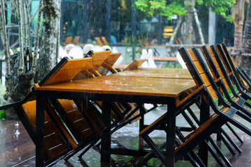 Fototapeta na wymiar Raining on tables at outdoor restaurant, wet table