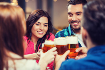 friends drinking beer and clinking glasses at pub