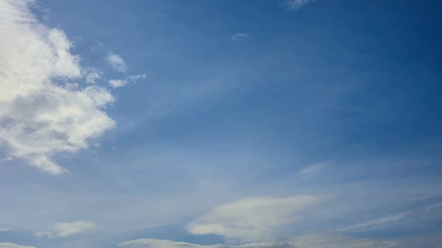 Time lapse video of white cumulus and fleecy clouds morphing on blue sky into grey stormy clouds, weather change