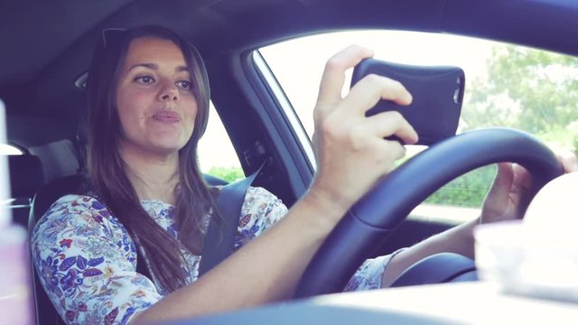 Woman having fun taking selfie while driving car dangerous retro style