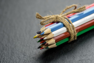Colored pencils tied with twine on wooden table