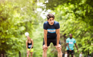 Young fit hispanic man resting after finishing race.