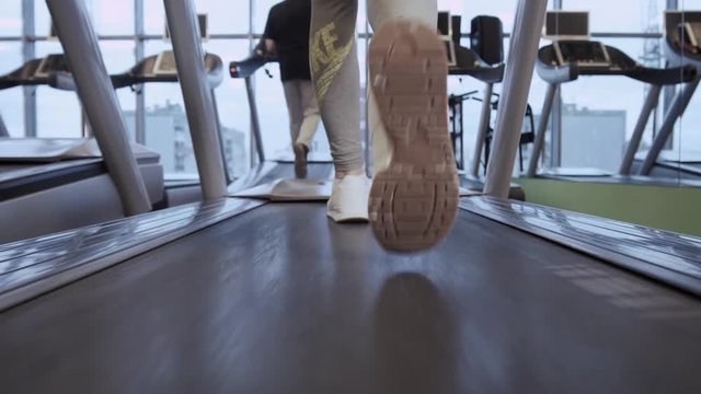 Detail of close up legs of woman running on treadmills gym