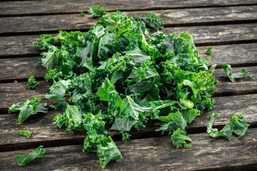 Fresh green healthy superfood vegetable kale leaves on wooden rustic table