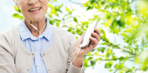 happy senior woman with smartphone and earphones