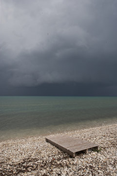 Beach at Acharavi Island of Corfu Greece. Dark clouds at the coast. Mediterranean sea