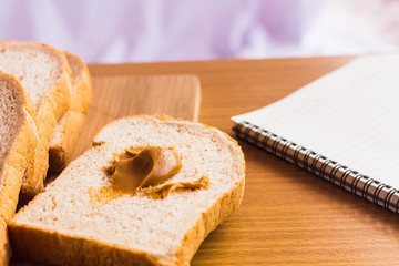 peanut butter and breakfast on wood table with book