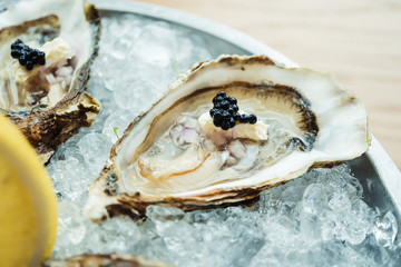 Raw and fresh Oyster with caviar on top and lemon