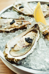 Raw and fresh Oyster with caviar on top and lemon
