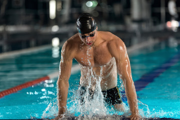 Male swimmer lifting himself out