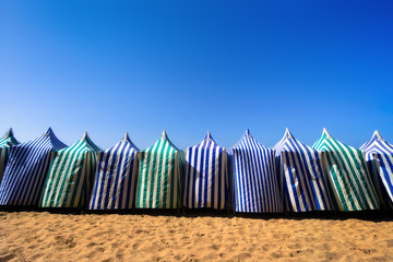 sunshades in beach at summer against blue sky