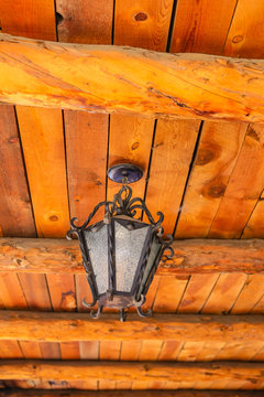 Old fashioned lantern hanging from a wooden ceiling