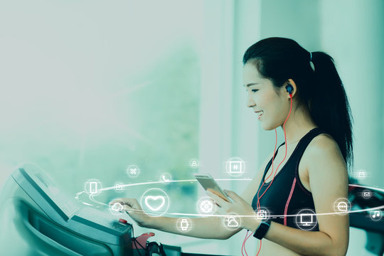 A asian woman using smartphone and smartwatch when her workout with IOT, internet of things sign and icon surrond her. Digital era or omni channel concept. Internet on everyday.
