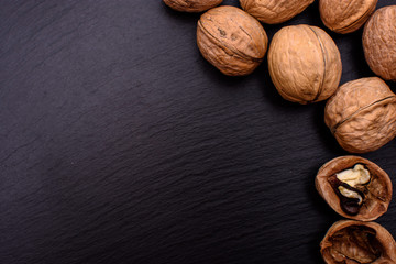 Walnut on black stone board background, frame space for text
