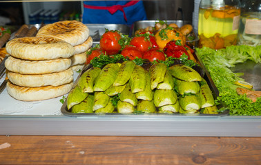 Delicious roasted fresh vegetables in a metal tray near buns for burgers