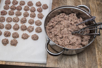Meatballs preparation with use ice cream scoop, on white marble cutting board, salt, pepper