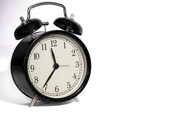 Black, vintage alarm clock with qwhite background