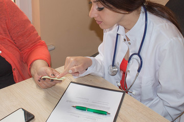 Doctor Discussing Records With Senior Female Patient. Doctor and patient