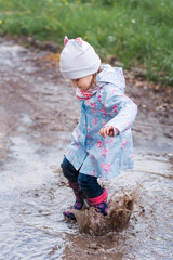 Little girl jumping in the puddle