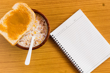 peanut butter and breakfast on wood table with book
