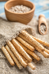 Fresh baked grissini bread on wooden board.