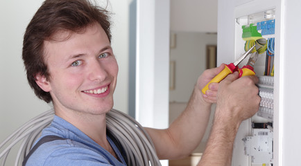 Ein Elektriker bei der Arbeit an einem Sicherungskasten