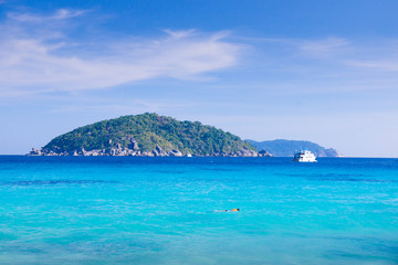 Naklejka premium A boat floating in turquoise sea in Summer at Similan island - Phang nga Thailand