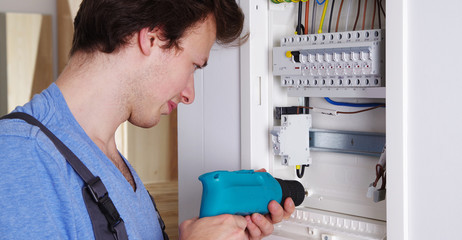 Ein Elektriker bei der Arbeit an einem Sicherungskasten