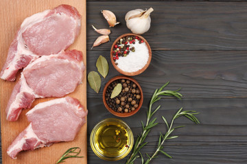 fresh raw meat with spices on wooden table. top view with copy space
