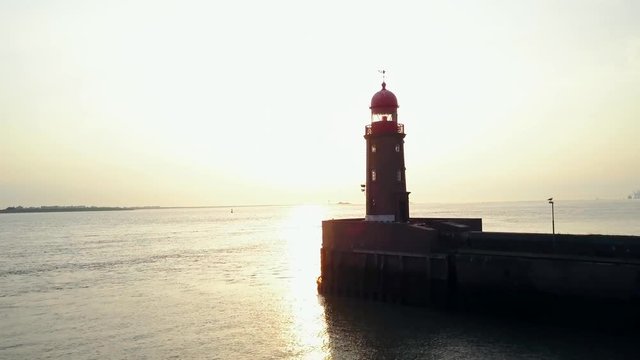 Flying towards a lighthouse with a boat in the sunset