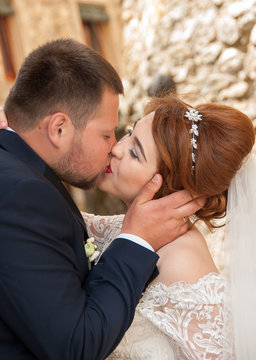 Kiss of the bride and groom. Wedding shot in the old town.  Warm embraces and gentle touches.