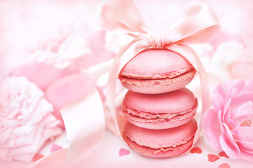 Raspberry and strawberry pink macarons on pastel valentine decor and rose flowers soft background