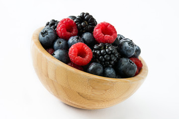 Healthy berries in wooden bowl isolated on white background
