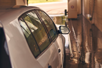 Clean silver colored automobile in car wash service interior