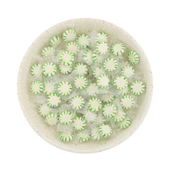 Top view of spearmint starlight mints in a shallow bowl isolated on a white background.
