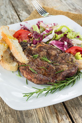 Braciola di maiale arrosto con contorno di insalata fresca e crostini 