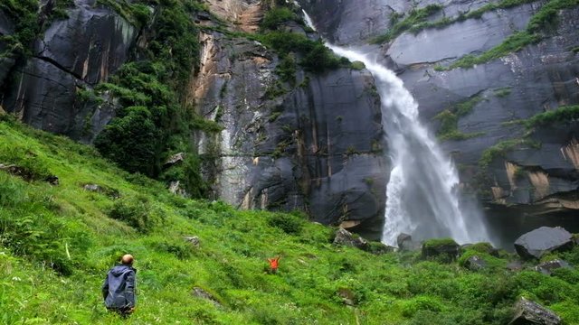 Two travelers greet each other at the Jogini waterfall in Vishesht, near Manali, India