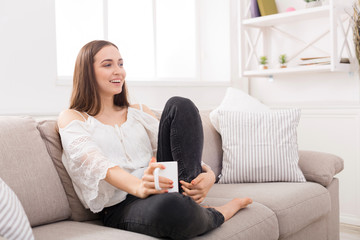 Laughing woman at home with coffee cup