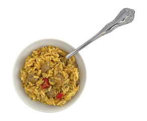 Top view of a bowl of pilau rice mixed with Korma curry sauce plus a fork in the food isolated on a white background.