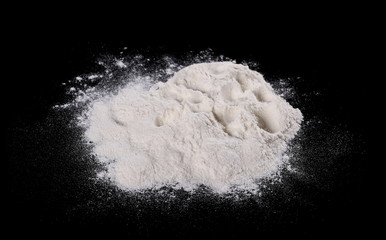 Pile of wheat flour isolated on black background,