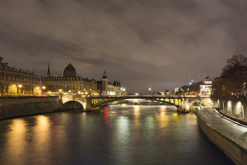 Fototapeta premium View of long exposed Seine river and historical architecture buildings in Paris at night in winter.