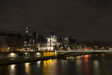Naklejka premium View of long exposed Seine river and historical architecture buildings in Paris at night in winter.