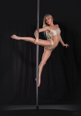 Beautiful slim girl with pylon. Female pole dancer woman dancing on a pole