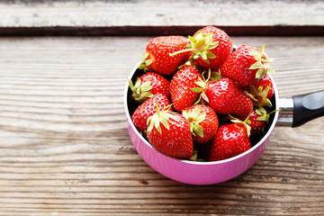 Ripe red strawberries on wooden table