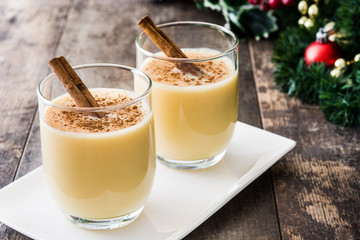 Homemade eggnog with cinnamon on wooden table. Typical Christmas dessert.
