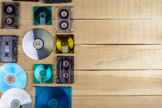 Musical cassette discs lie on a wooden table