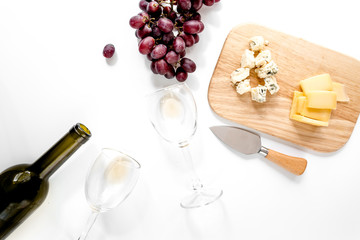Set for drinking wine with cheese and red grape on white background top view