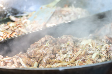 Heiße Pfanne mit Gyros und Zwiebeln im Bratendunst