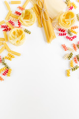Assortment of different shape italian pastas on white background top view copyspace